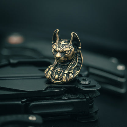 Brass Close-up of Bastet paracord bead with intricate Egyptian-style carvings, ideal for knife lanyards and custom EDC accessories.