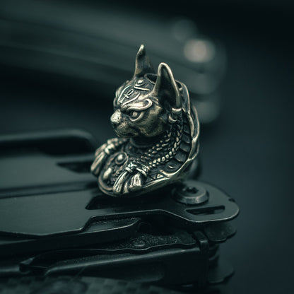 White brass Close-up of Bastet paracord bead with intricate Egyptian-style carvings, ideal for knife lanyards and custom EDC accessories.