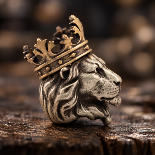 Close-up side view of a crowned lion EDC paracord bead showing the detailed face, layered mane, brass crown and aged metal texture.