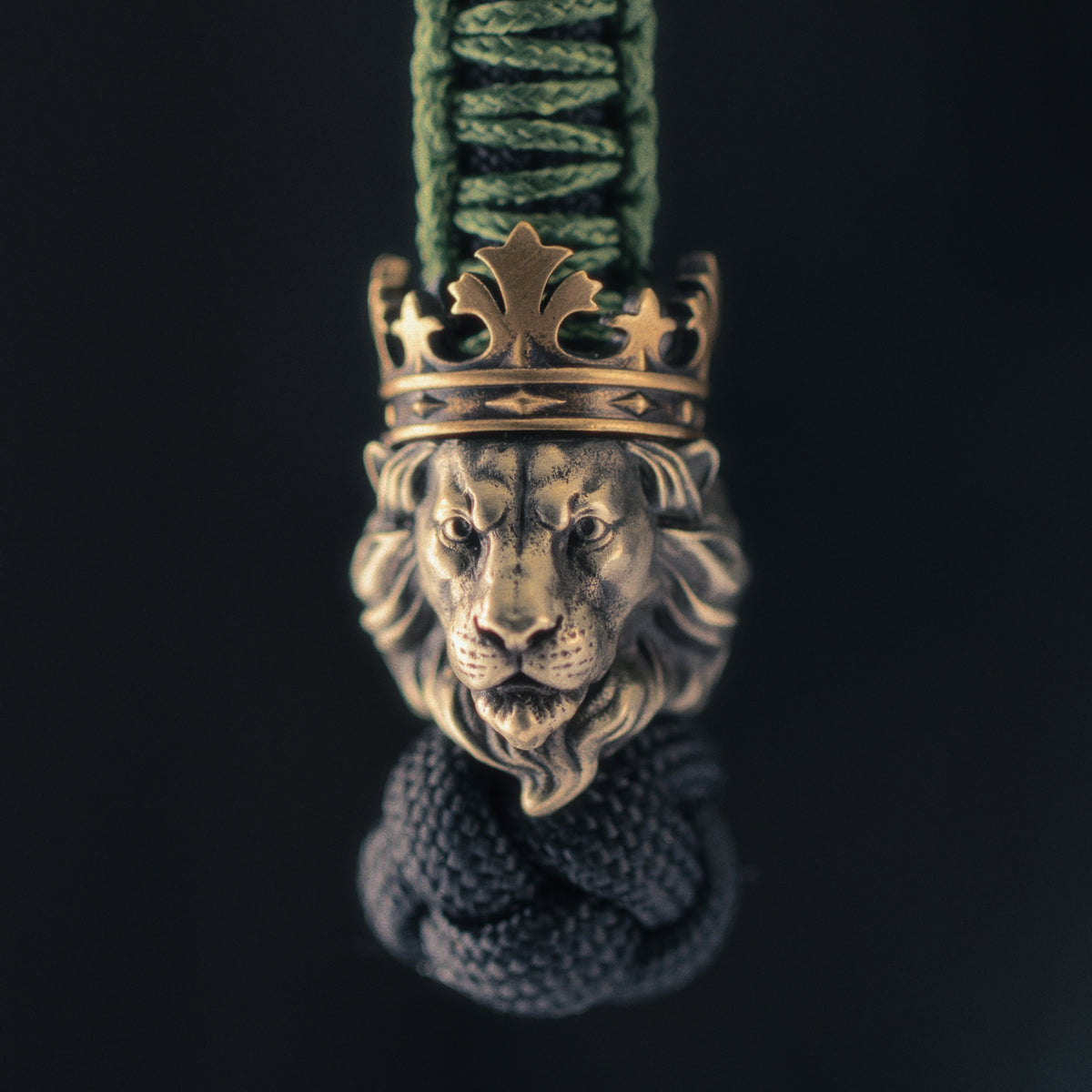 Front view of the ShadowEDC Lion King paracord bead with a sculpted lion face, layered mane and contrasting antique brass crown.