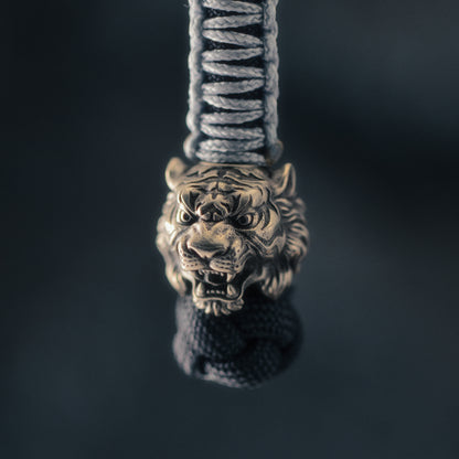 Brass tiger head paracord bead mounted on a green knife lanyard, designed for standard 550 paracord and EDC gear.